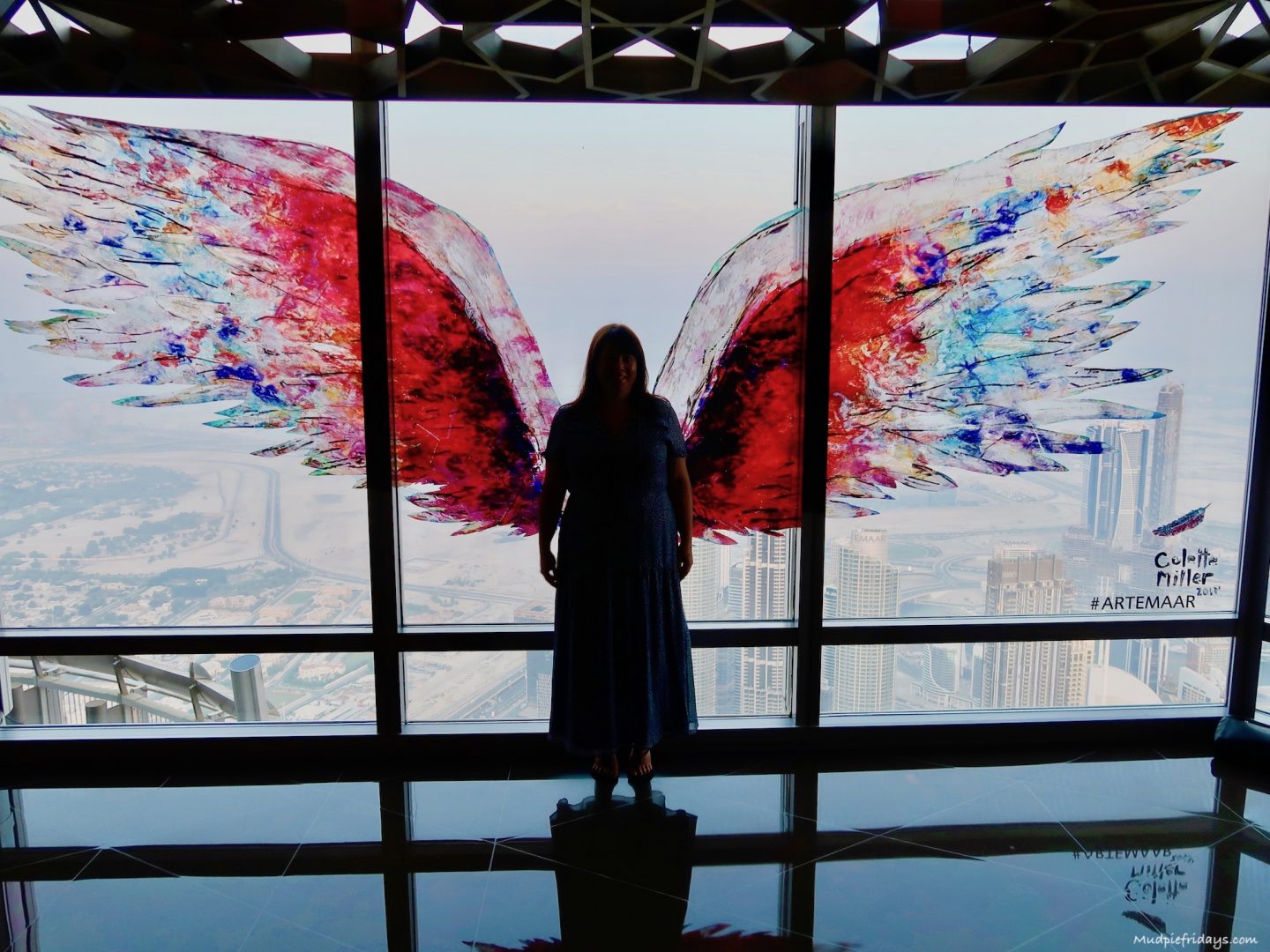 Standing in front of the wings painted on the glass