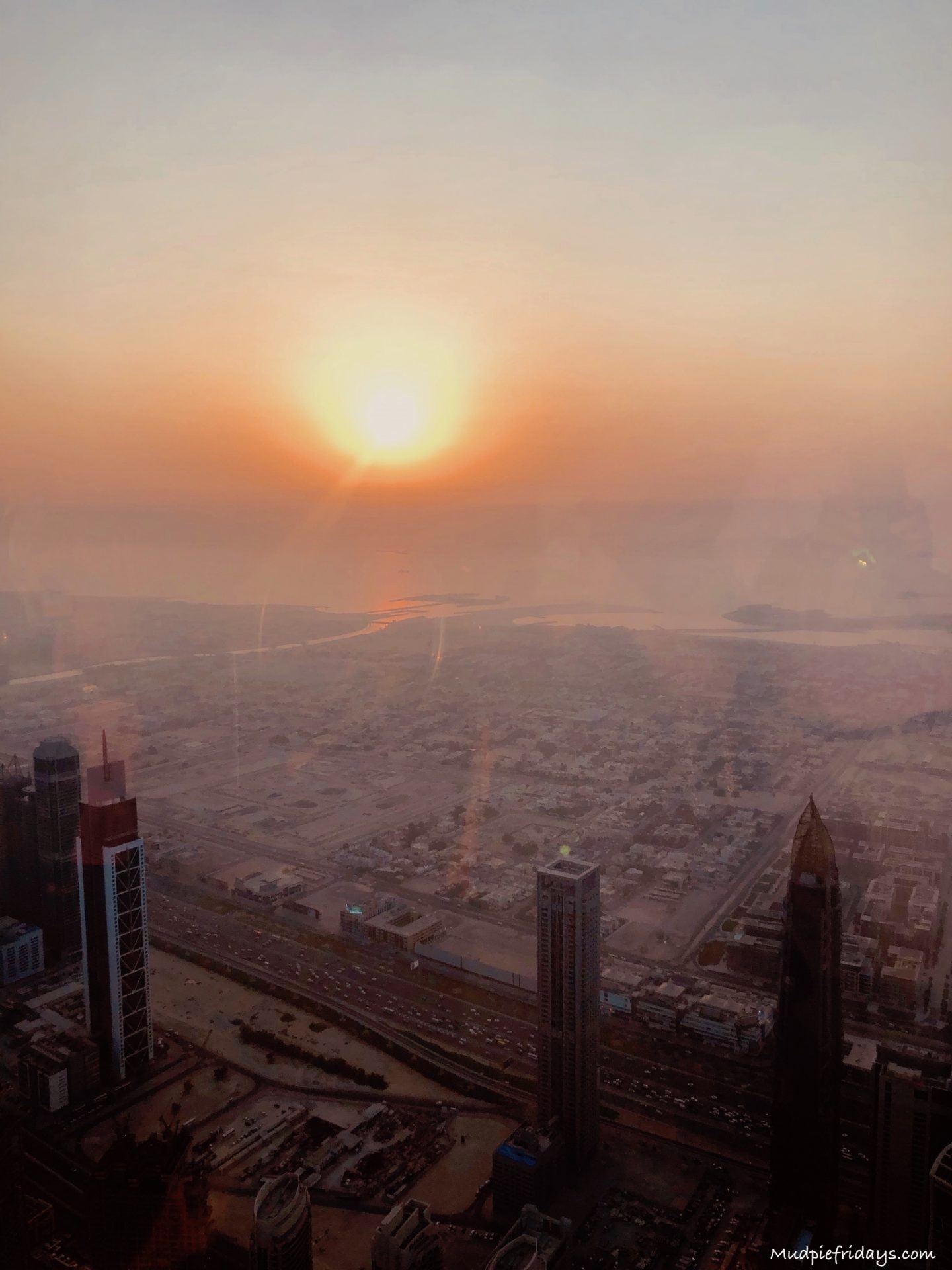 views across Dubai from the 125th floor of the Burj Khalifa with the sun setting