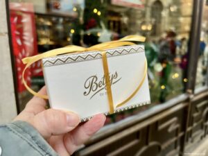Cake box from Betty's York outside the tea room with gold ribbon