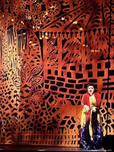 A singer in front of the red curtain at Cirque du Soleil LUZIA at the Royal Albert Hall