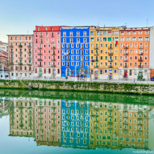Colourful apartment blocks in Bilbao overlooking the river with reflection taken from the Ribera market