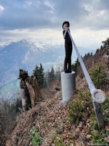 Wooden carved statue holding a alphorn at the top of Harder Kulm