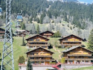 The Grindelwald First cable car with traditional swiss wooden gondolas in the background