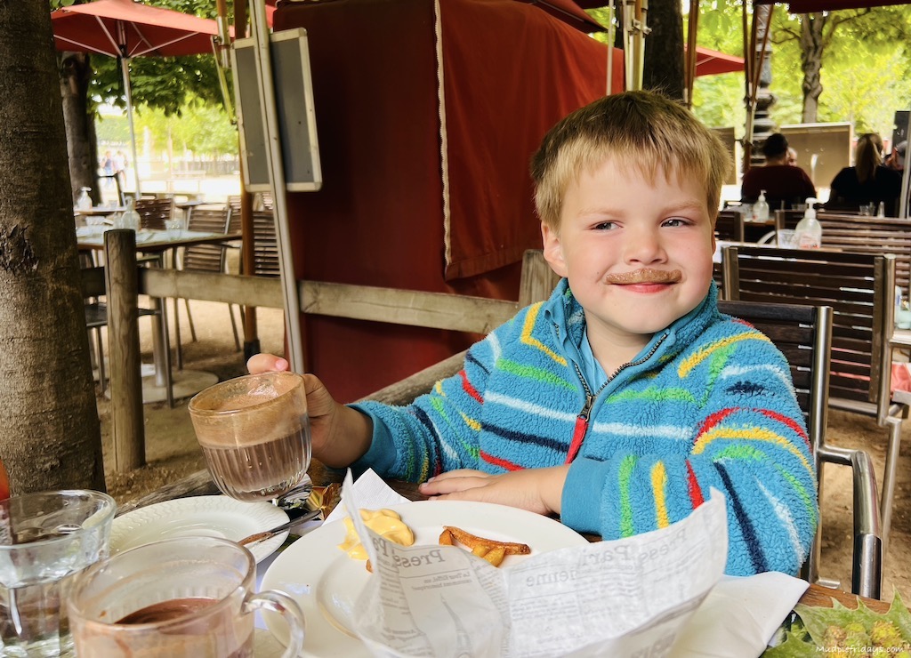 harry drinking french hot chocolate on our Paris family vacation