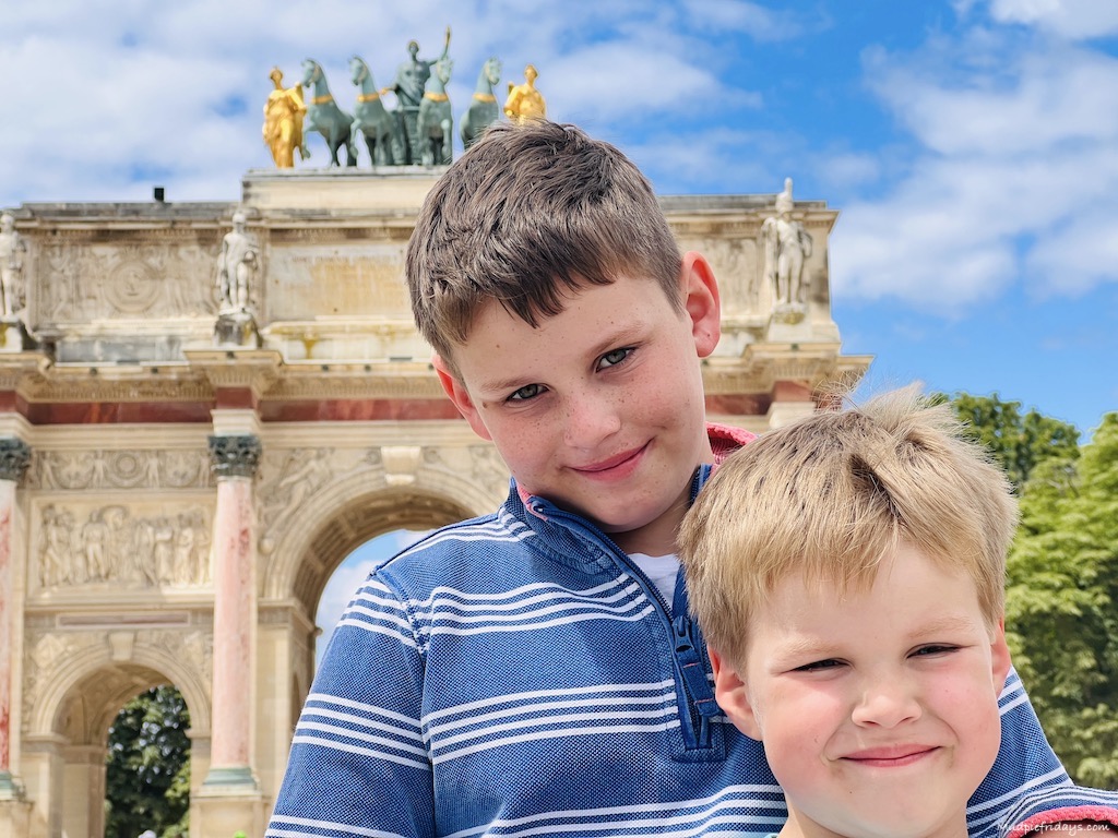 The boys in a Parisian park with an impressive gate