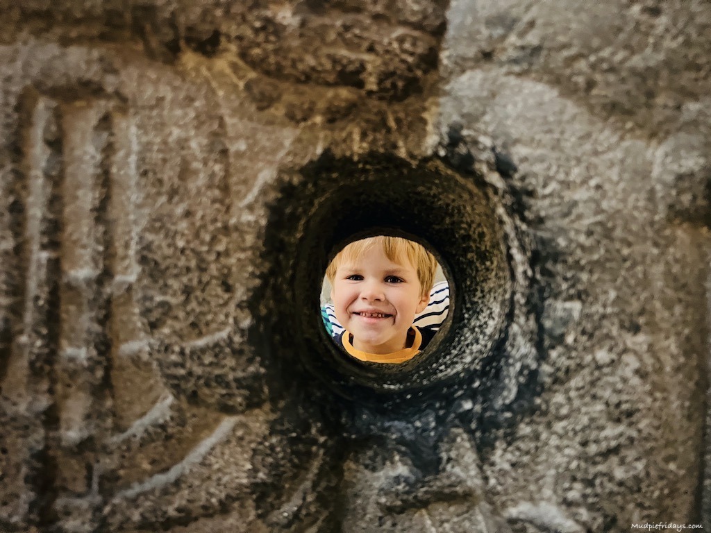 harry peakng through a stone