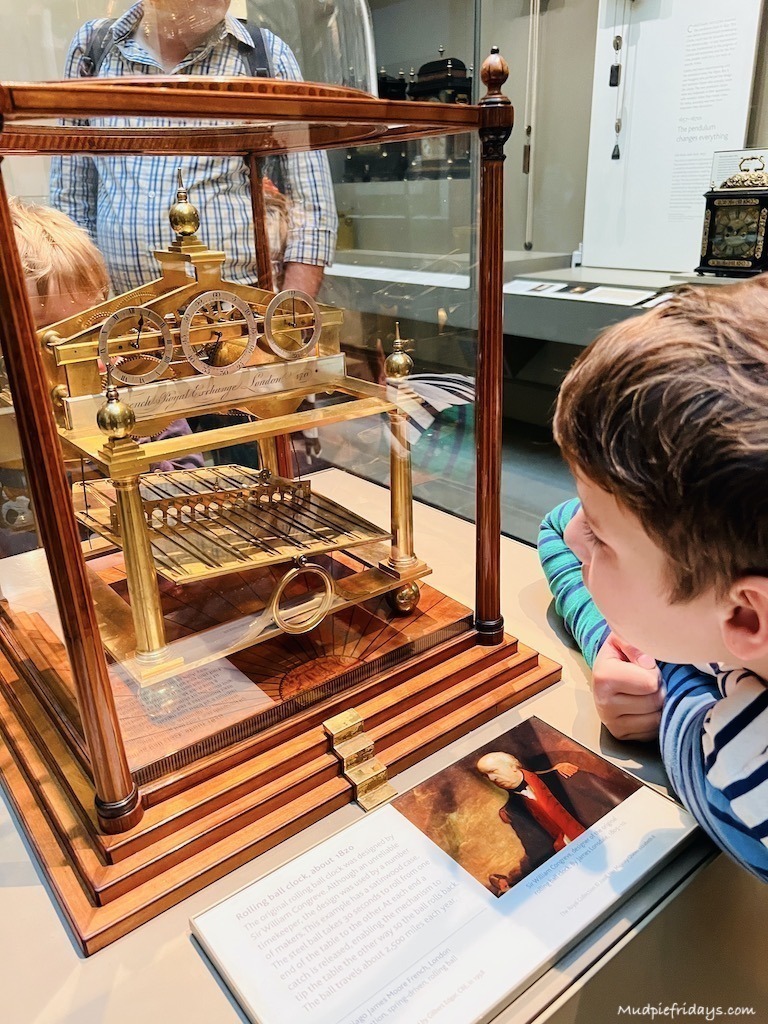 Boys watching a clock which operated with a marble