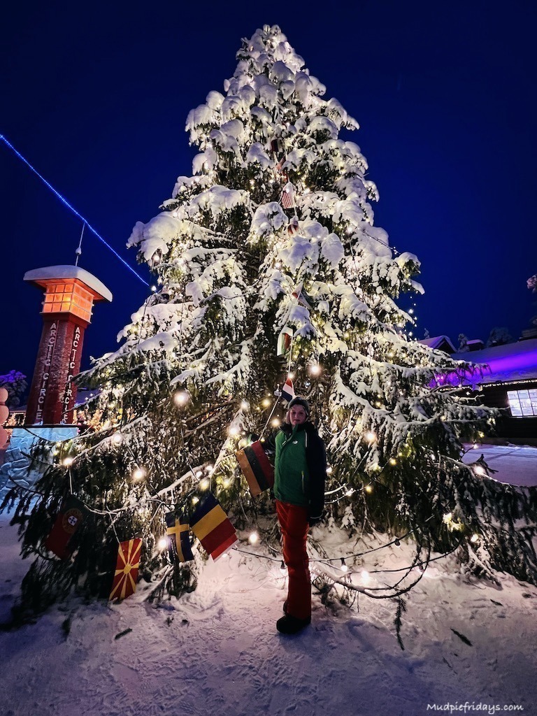 Charlie in front of the giant christmas tree at Santas Village at Christmas in Lapland
