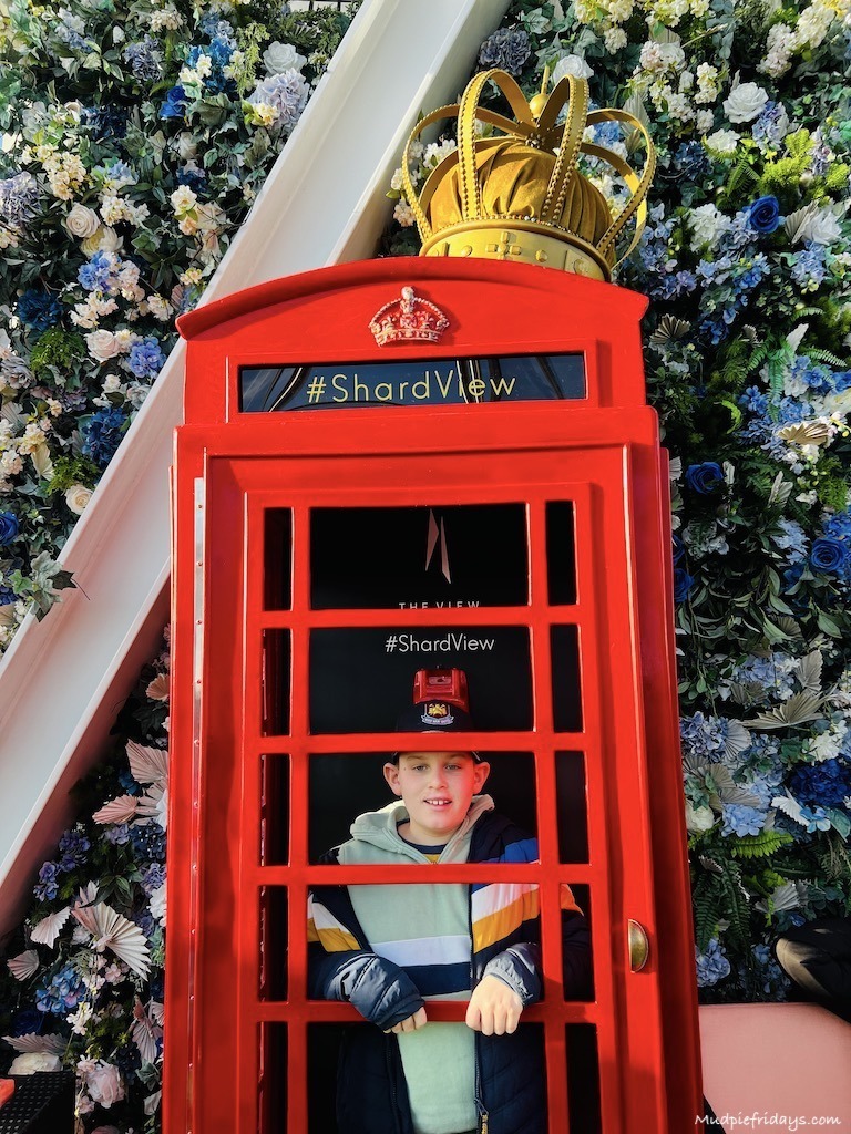 Charlie in a phone box posing for a photo