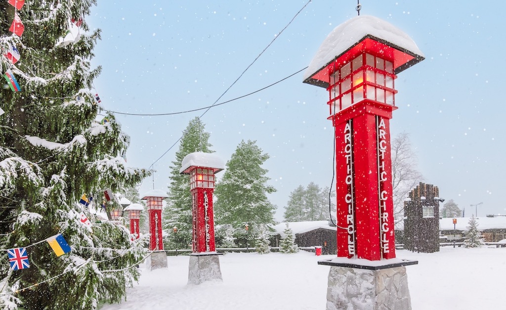 Crossing the arctic circle with the red posts at Santa Claus Village on a Lapland bucket list