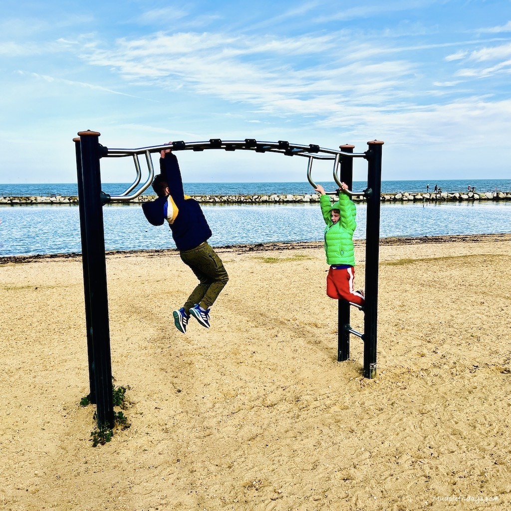 Boy swinging on the trim trail at the beach