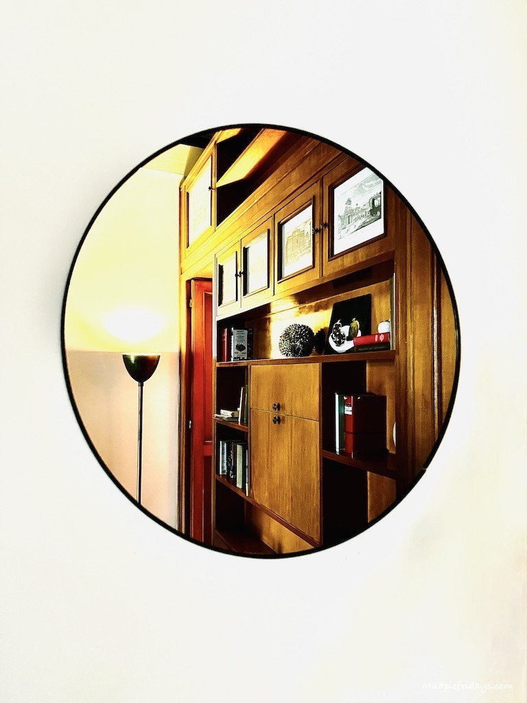 A picture of one of the mirrors reflecting the living area and cabinet