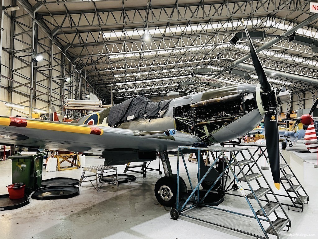 A spitfire with work being undertaken on its engine at the air museum duxford