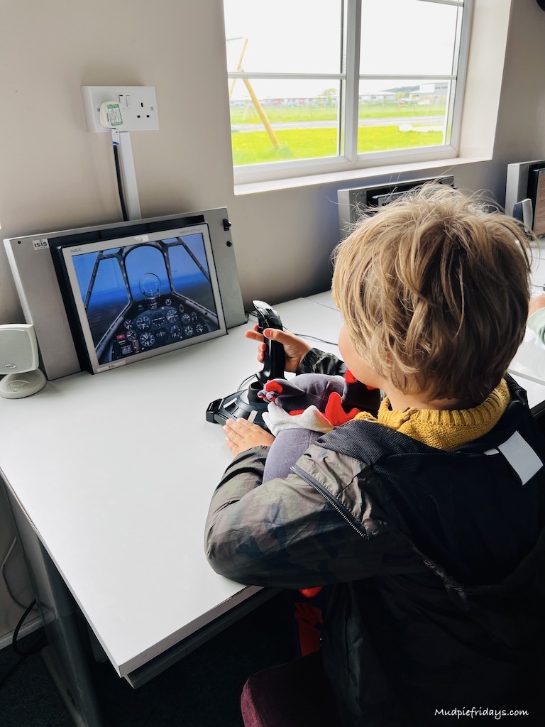 Harry playing on the simulator in the interactive area of the air museum somerset