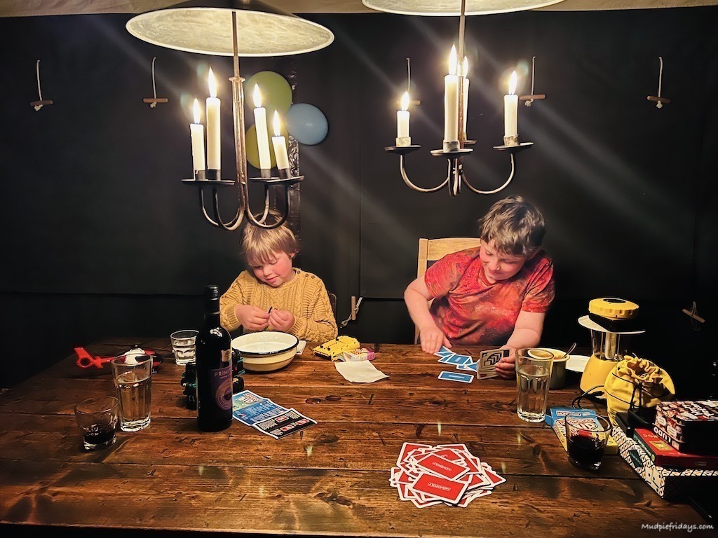The. boys playing card games by candle light while glamping in somerset