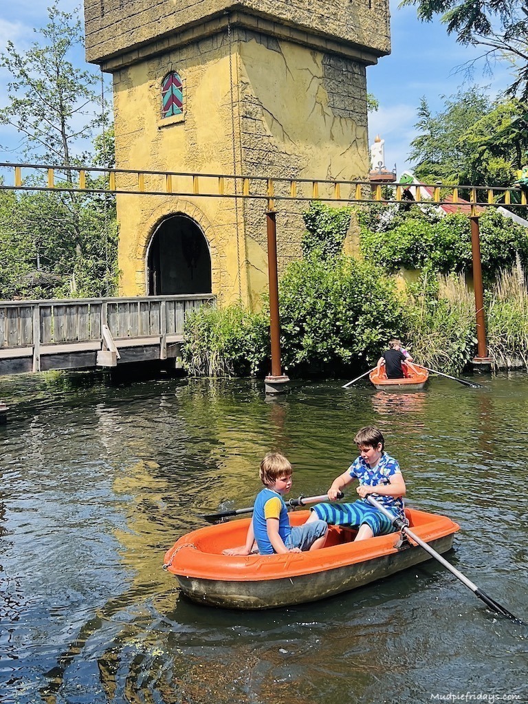 The boys in a rowing boat in part of Wonderland at Duinrell Amusement Park - Eurocamp in the Netherlands