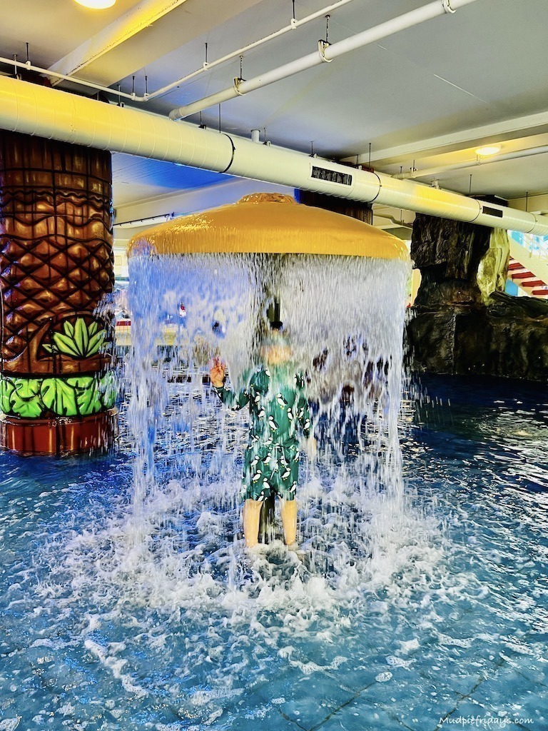 Harry in a water fountain in the heated play pool at Tikibad water park