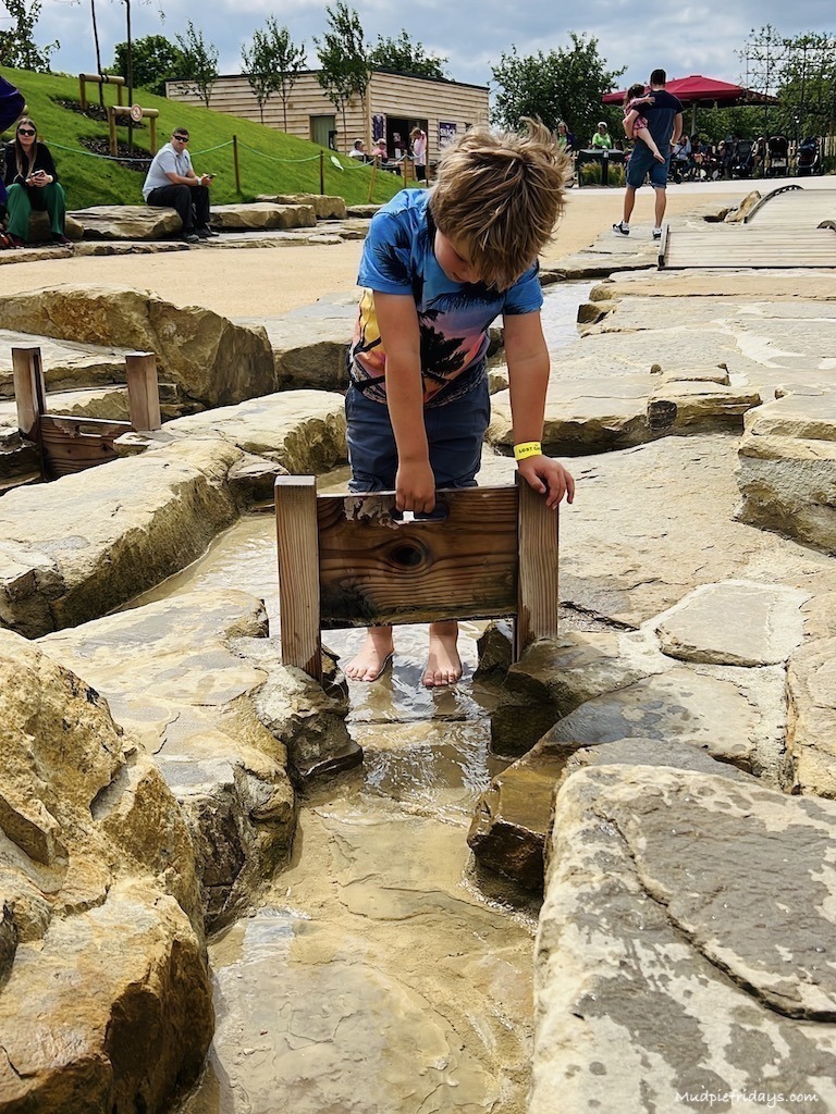 The water play area - harry playing with a wooden dam