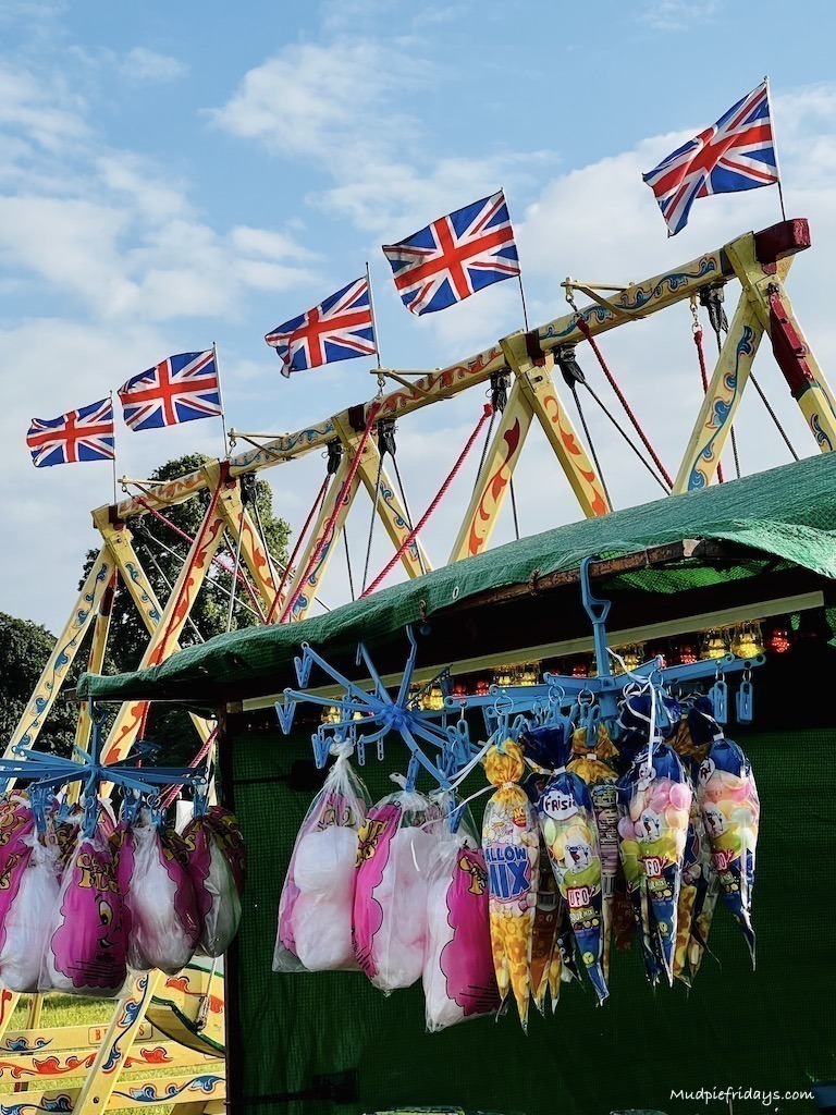Kids stall with candy floss and the chair swings in the background with Union Jack flags