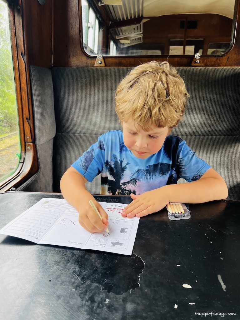Harry enjoying the free activity sheets while sitting on the steam train