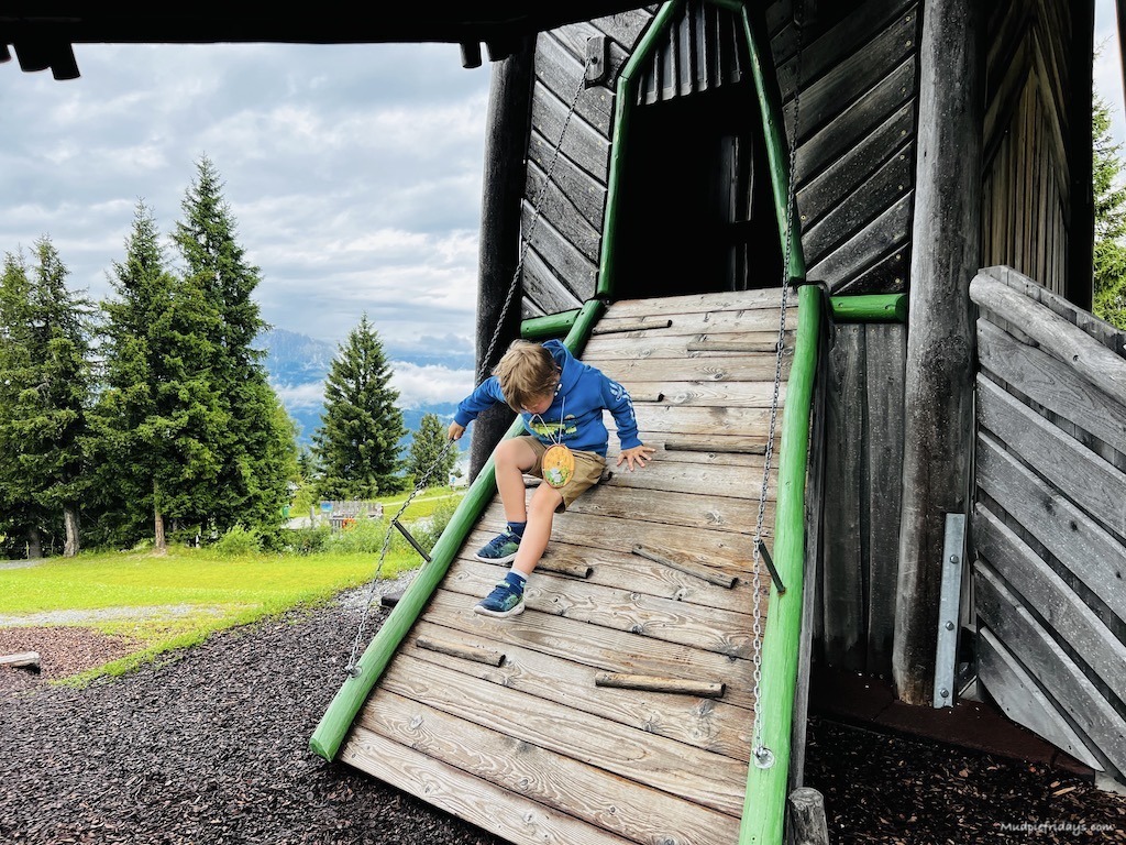Harry climbing down a wooden ladder in the adventure play area