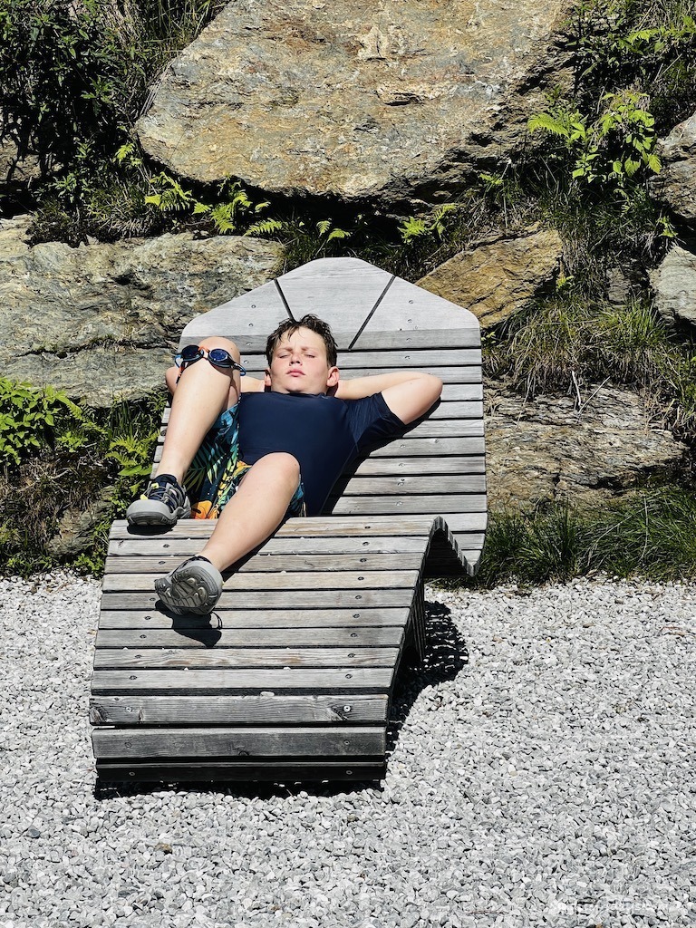 Charlie relaxing on a wooden sun lounger next to the Fichtensee