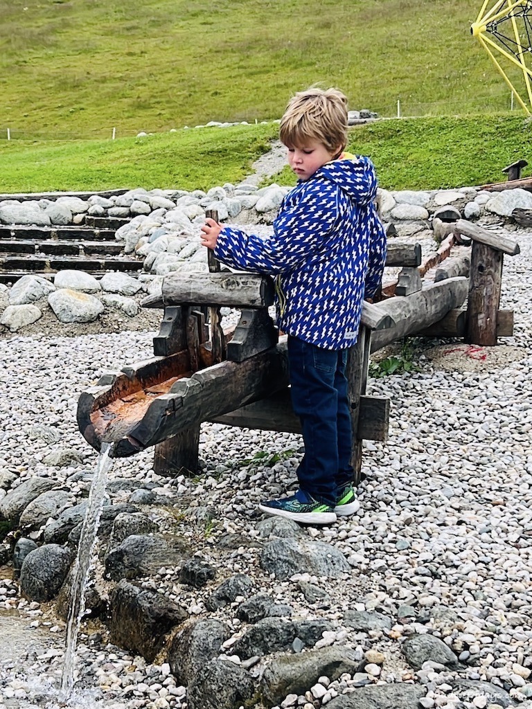 Harry playing with the water dams at The boys playing on the wooden play equipment and pools at the top of the Spieljoch Family Adventure Mountain