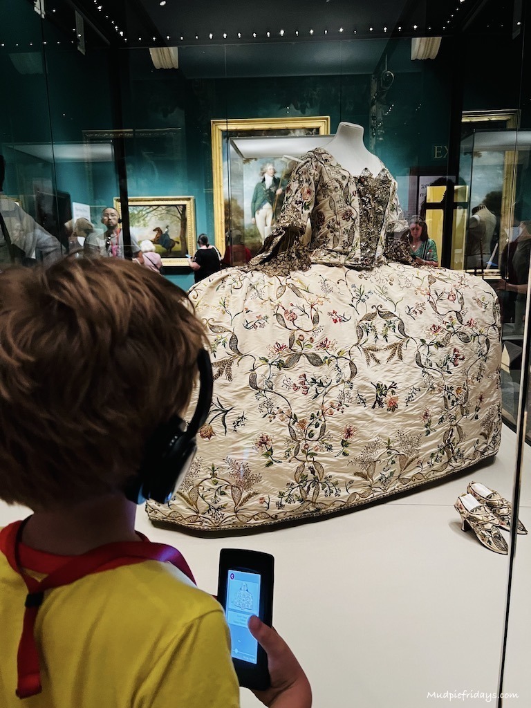 Harry looking at Queen Charlottes dress in the  Queens Gallery - visiting Buckingham Palace with kids