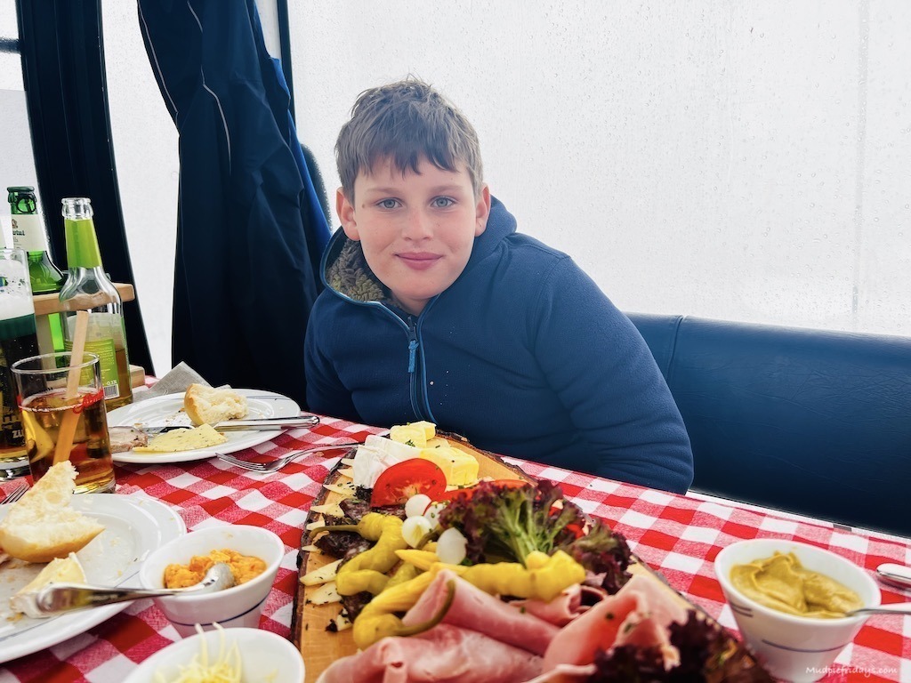 Charlie sitting in the gondola with a platter of food in front of him