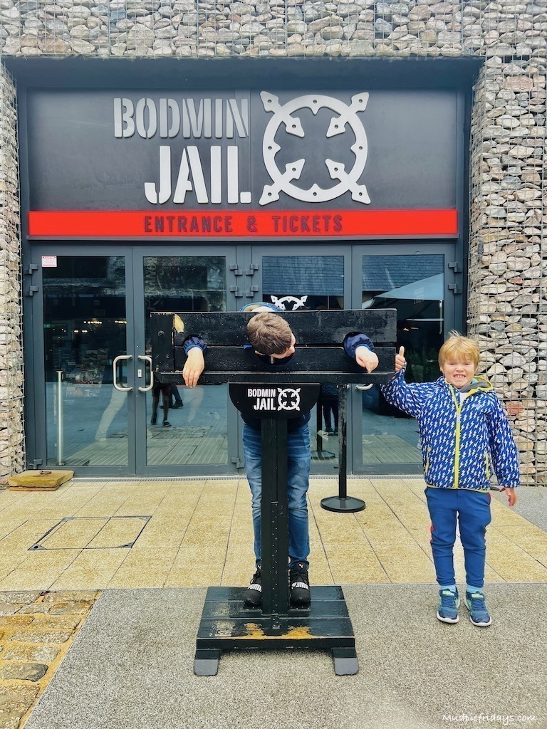 The boys standing outside Bodmin Jail with Charlie in the stocks
