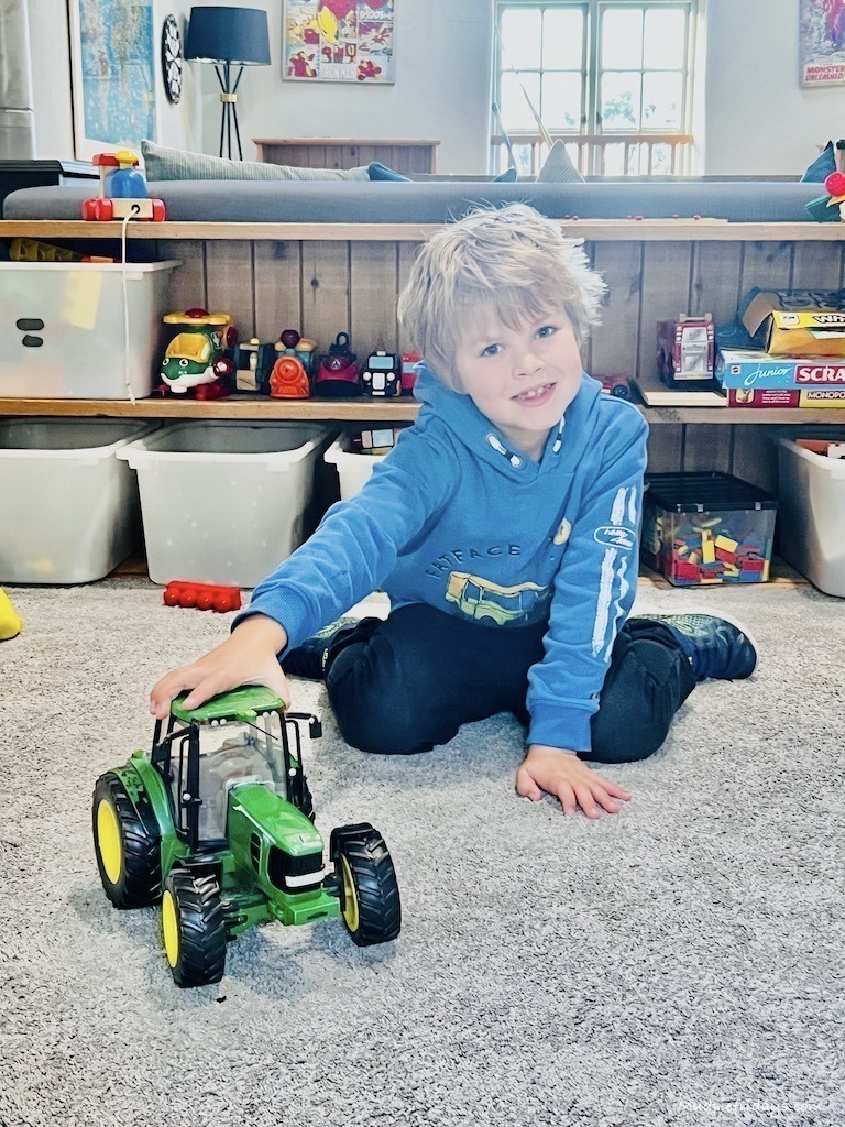 Harry playing with a tractor on a rug