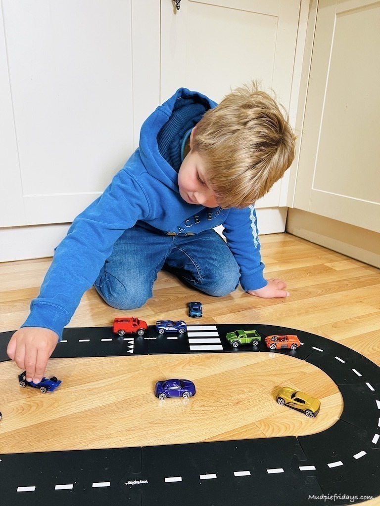 Harry playing with cars on a track