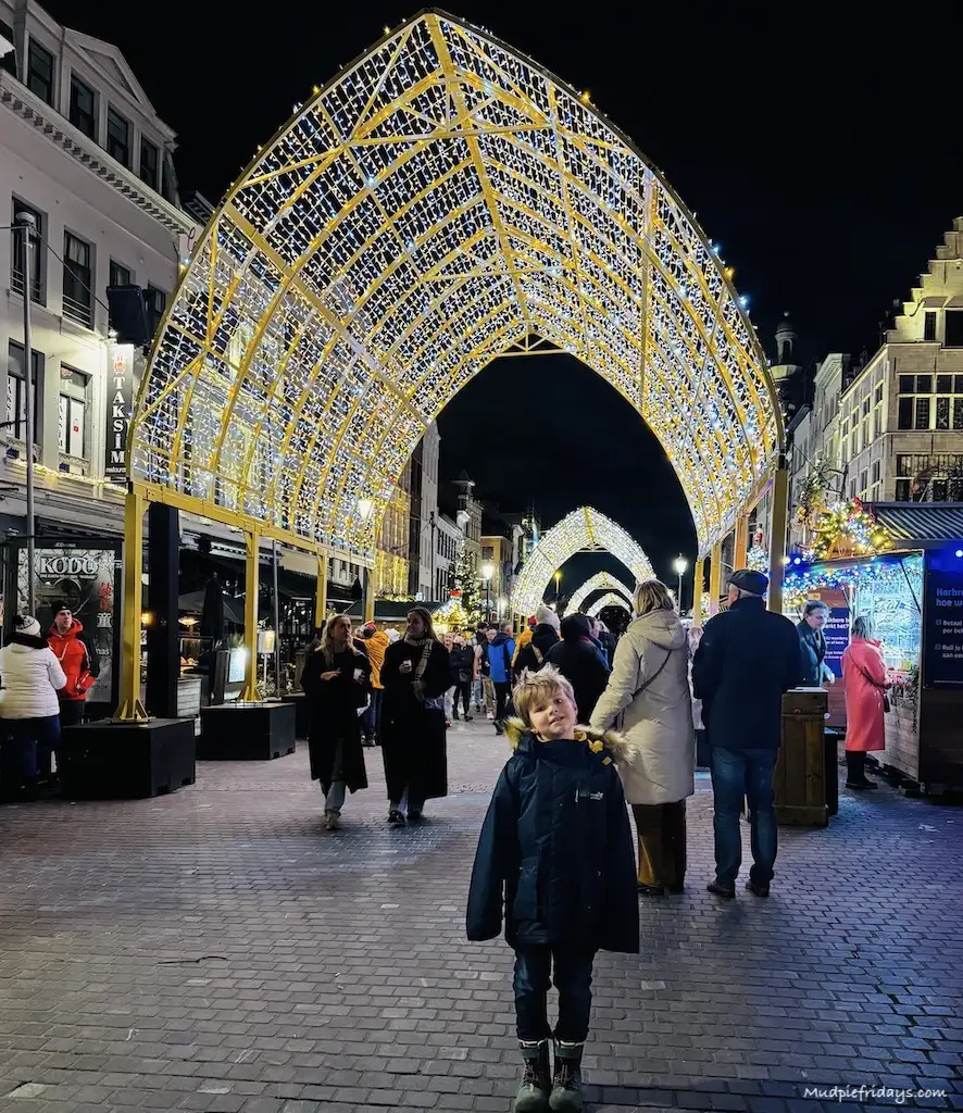 Harry standing under a golden archway all lit up