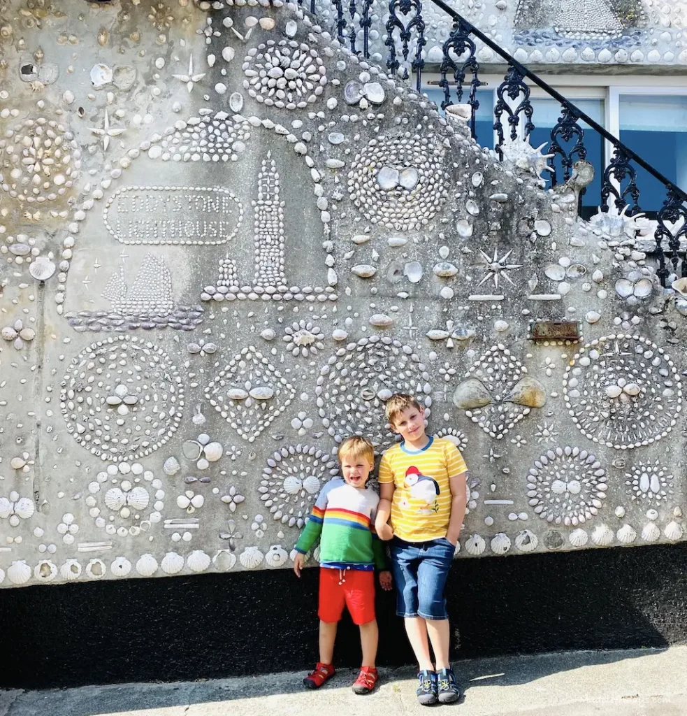 The boys standing in from of Polperro Shell House - things to do in Polperro