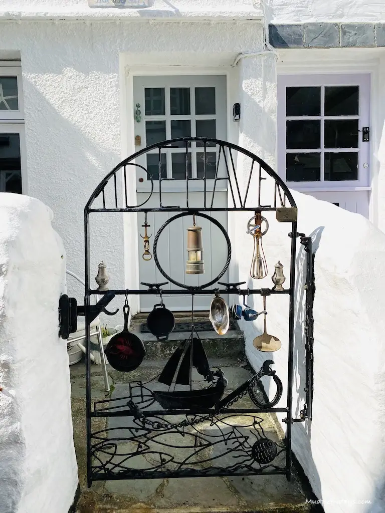 One of the white washed cottages and interesting things hanging from its gate