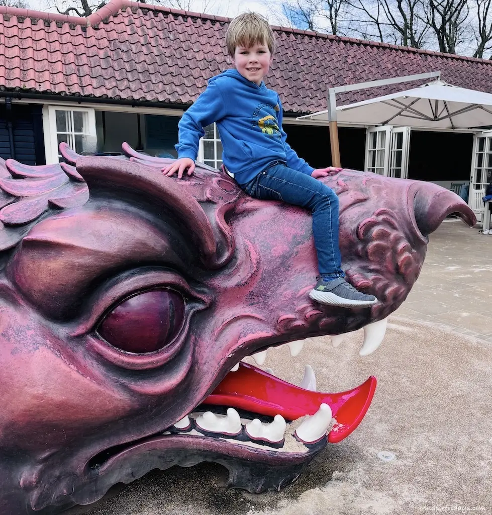 Harry sitting on the dragon which features in the Hampton Court Palace Magic Garden