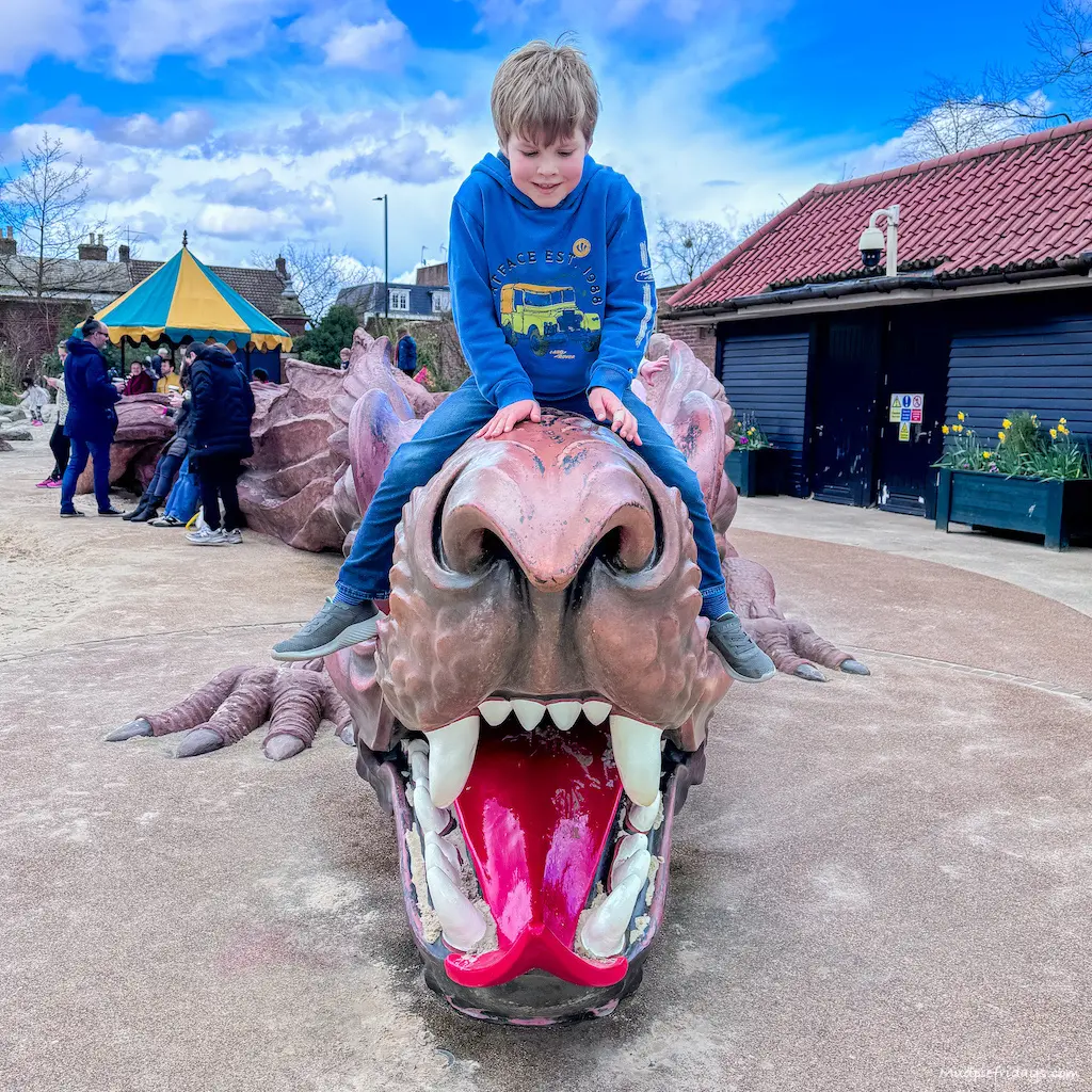 Harry sitting on the dragon which features in the Hampton Court Palace Magic Garden