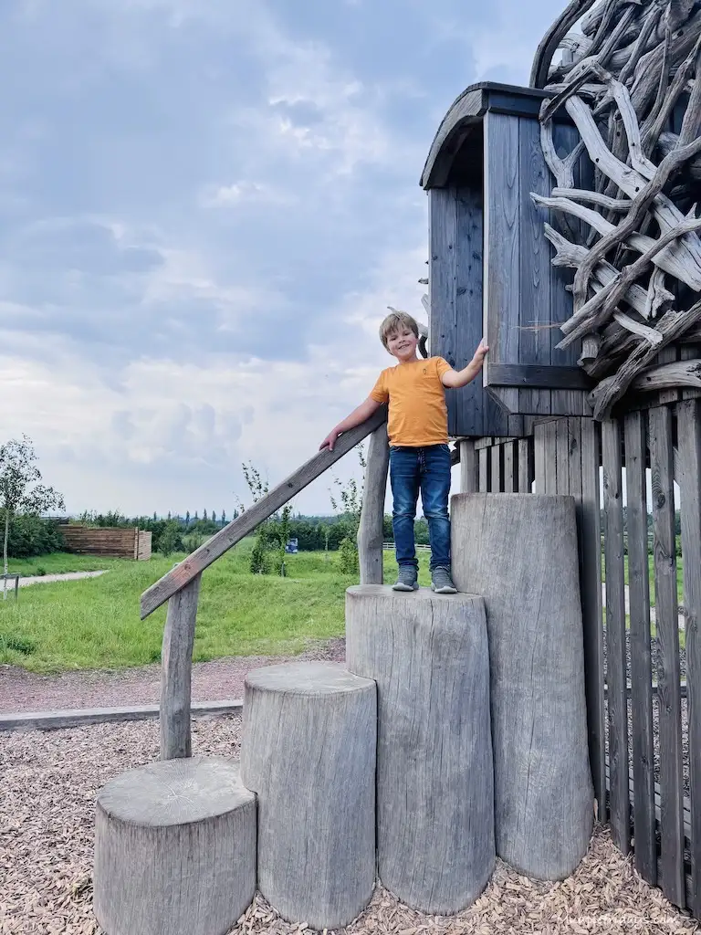 Harry standing on some tree trucks for the play area inside the wave bristol