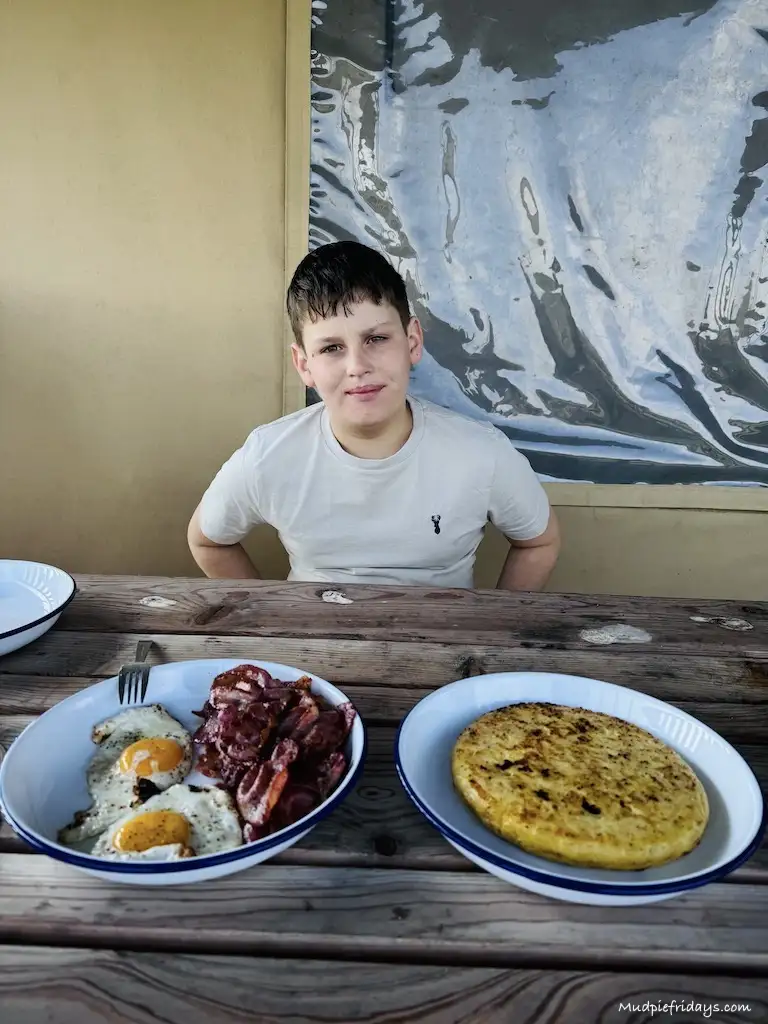 Charlie sitting outside with breakfast at the safari tent