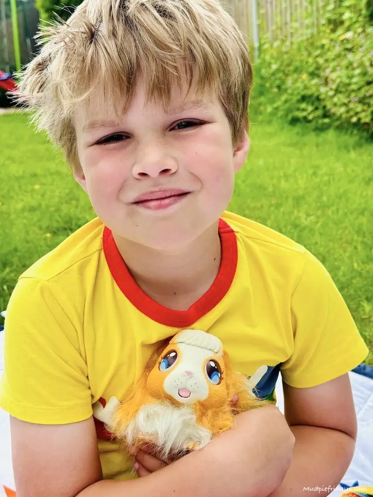Harry with the toy guinea pig cuddling it
