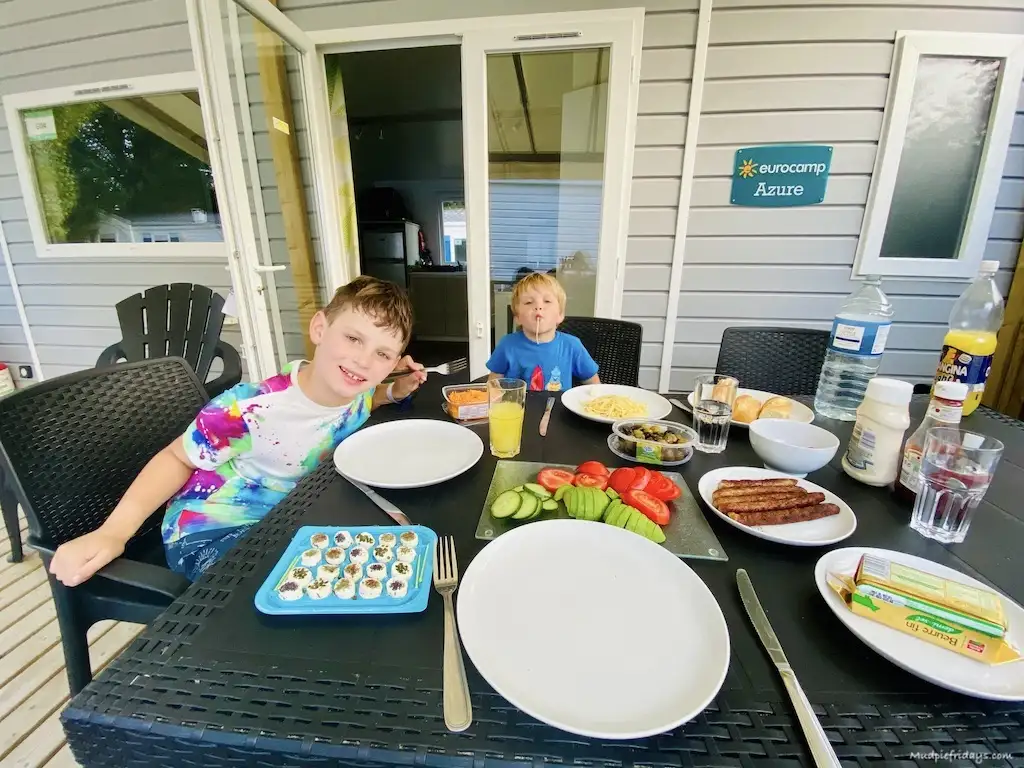The boys sitting outside on the veranda eating dinner
