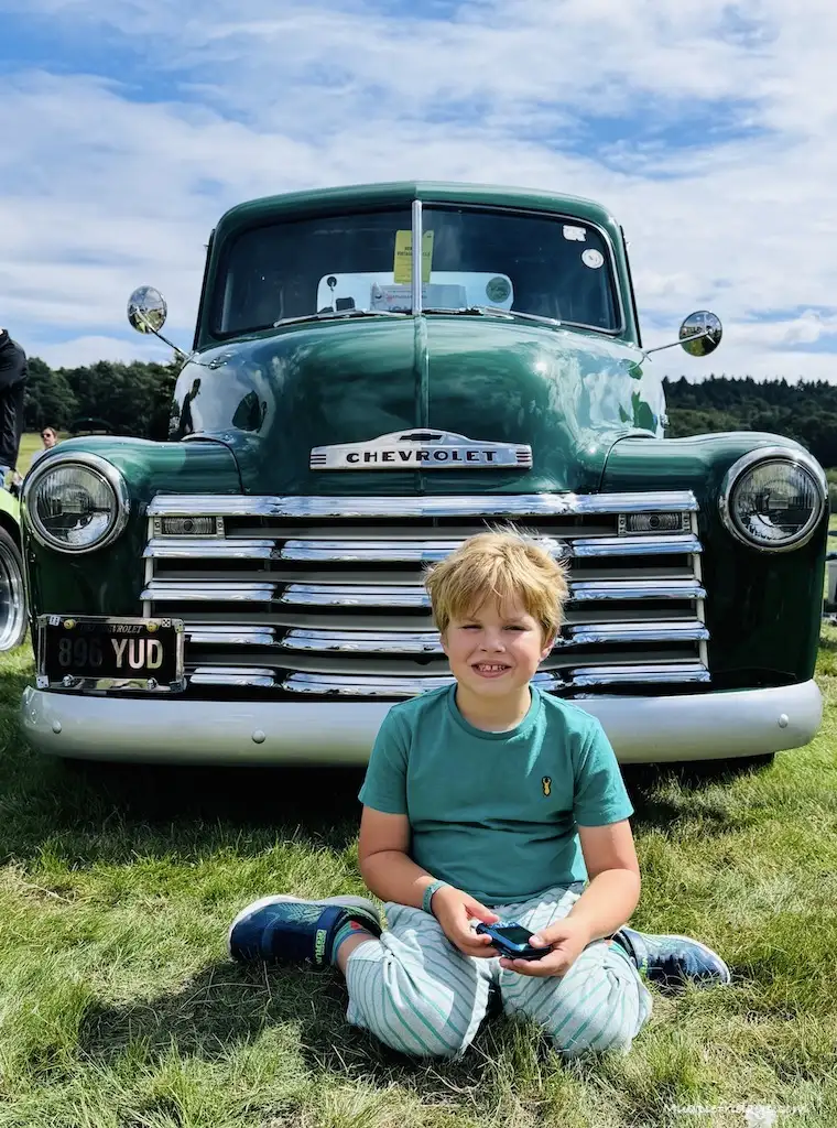 Harry sitting in front of a green chevlot truck from American