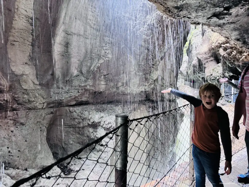 Harry playing with the water coming down the sides of the Partnachklamm