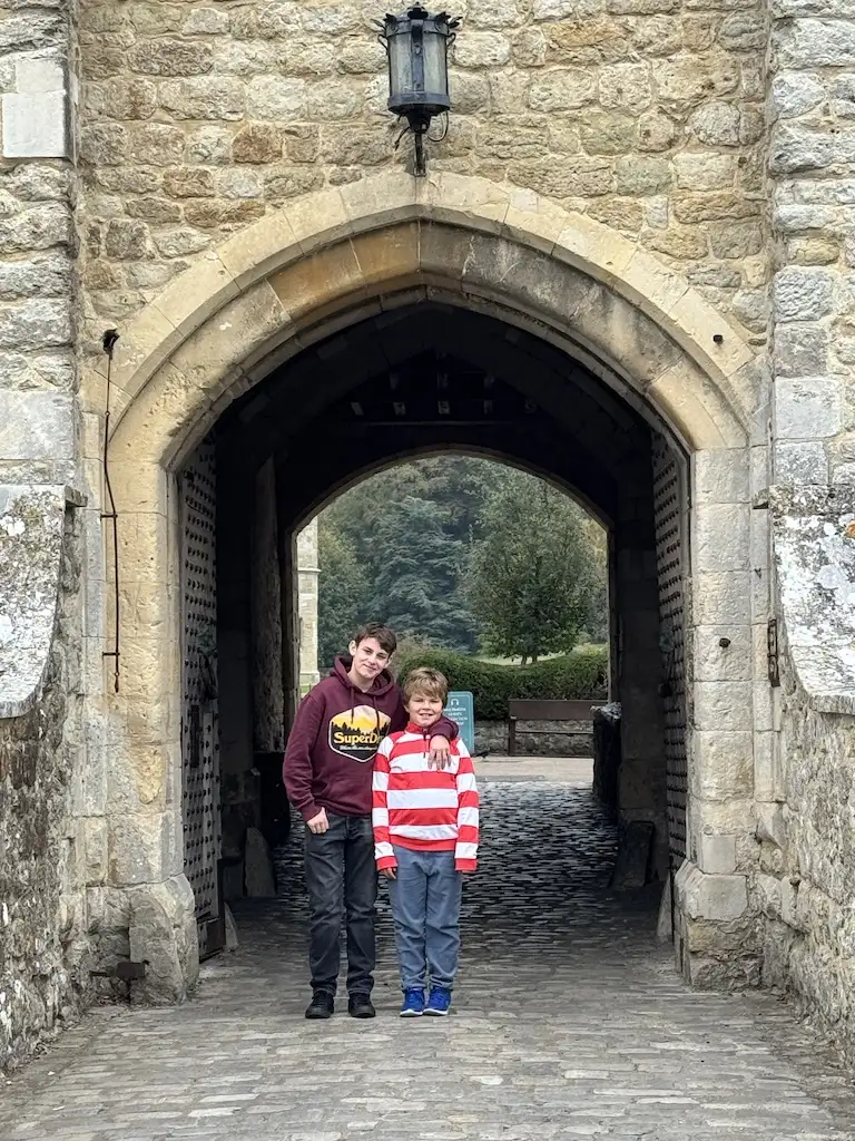 The boys standing in front of the entrance to leeds castle with on one else in the background